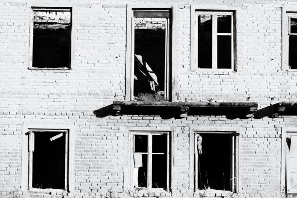 A old building with shattered glass and a neglected exterior.