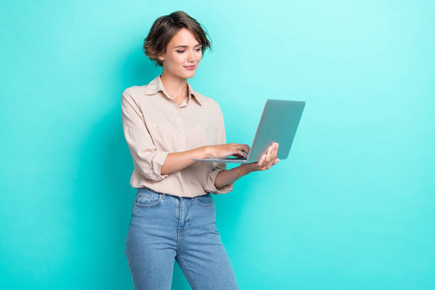 istock Photo of professional young focused confident woman coder it developer working google company hold laptop user isolated on aquamarine color background 2182249417