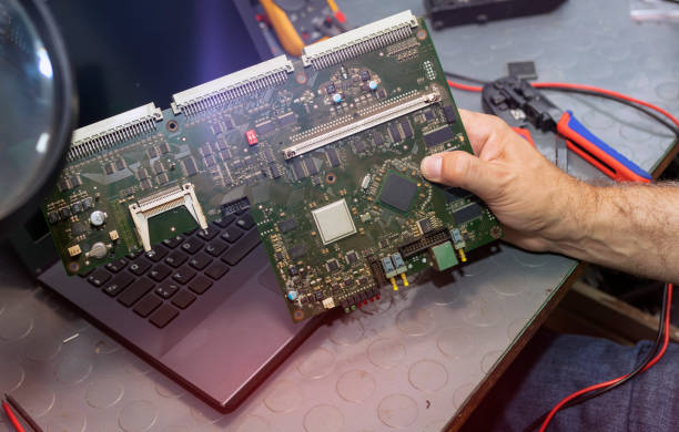 istock Engineer Holding Circuit Board Near Laptop in Workshop 2182249834