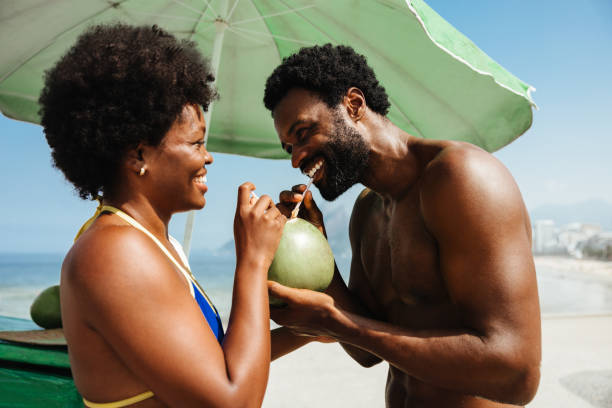 istock Smiling couple enjoying coconut drink on beach vacation 2182251372