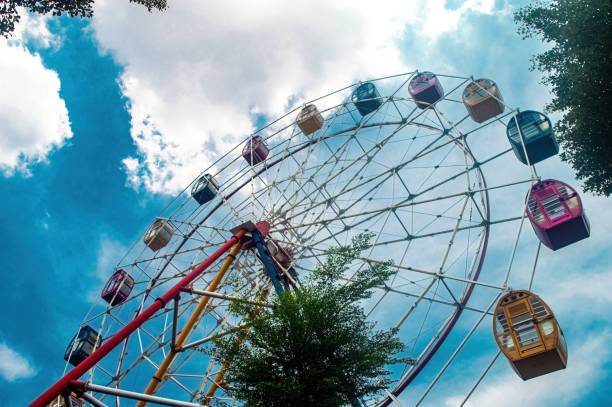 istock A vibrant Ferris wheel against a bright blue sky with fluffy clouds, perfect for amusement park promotions or travel blogs 2182256884
