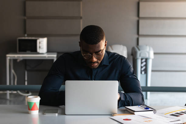 istock Black guy video chatting on tablet near laptop in workplace 2182257787