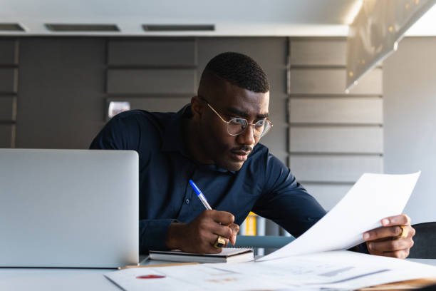 istock African American guy writing in notepad near laptop in office 2182257798