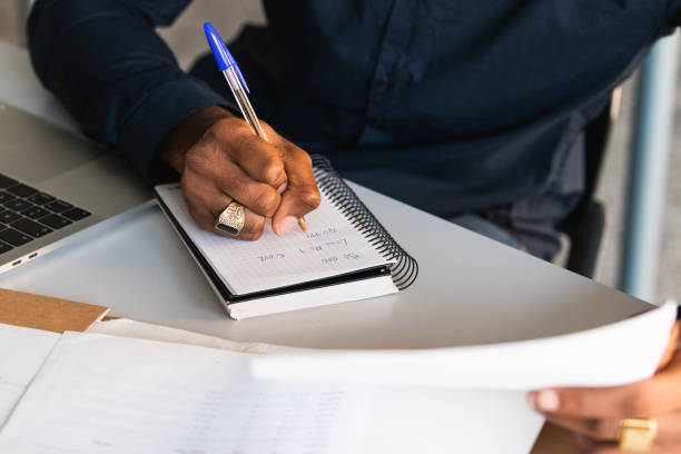istock African American guy writing in notepad near laptop in office 2182257884