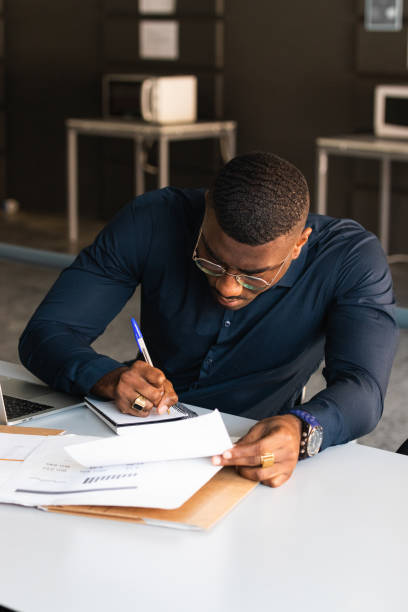 istock African American guy writing in notepad near laptop in office 2182257906