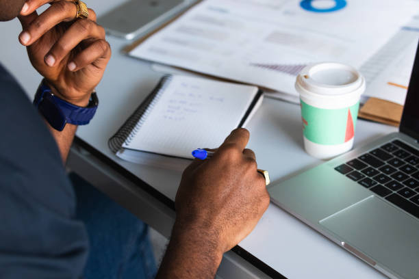 istock African American guy writing in notepad near laptop in office 2182257955