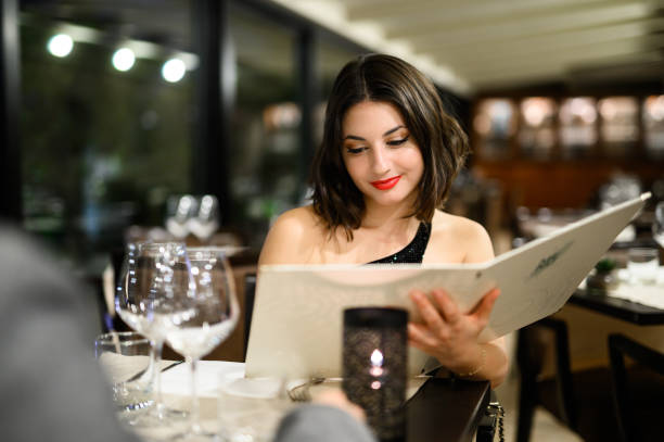 istock Elegant woman reading menu in a fancy restaurant 2182260315