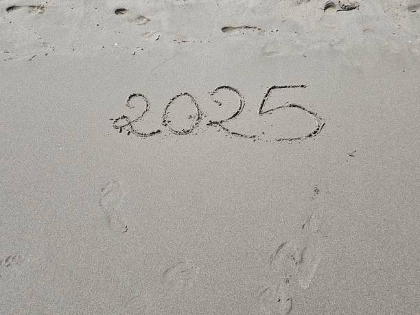 istock top view of year 2025 written on beach sand 2182261312