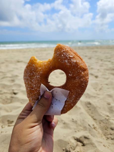 istock hand holding a donut at the beach - Morocco 2182261318