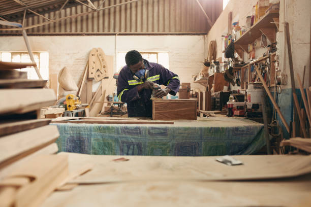 istock An African carpenter sanding wood while wearing a mask 2182263327