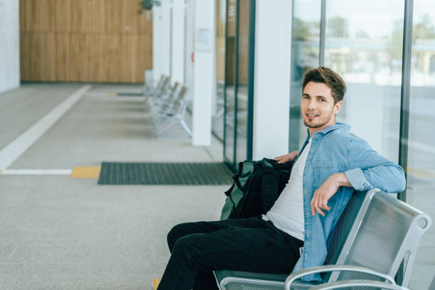 istock Young man waiting in modern transport station with backpack 2182265623