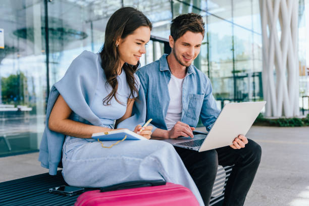 istock Couple business partners working with laptop, dressed casually, modern professional lifestyle. Travel, booking, preparation for journey. Collaborative and combining technology and travel 2182265700