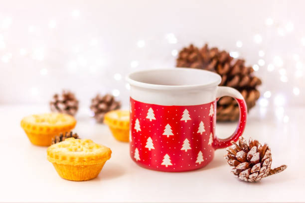 istock Christmas mug and mini cakes with snowflake and pine cone on table 2182266704