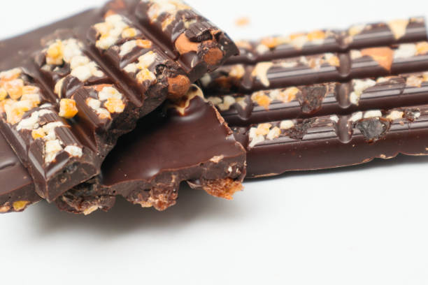 istock Dark chocolate bars with chopped nuts on a white background, side view. Dessert food. Dark chocolate in Pieces. 2182267233