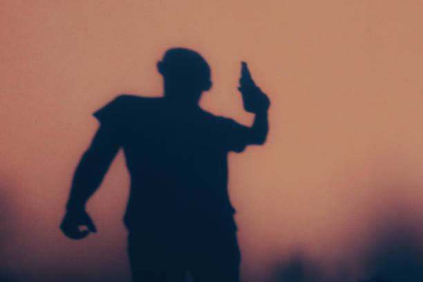 istock Shadow figure. A man drinks alcohol from a bottle. Back view of shadow. Young man with beer bottle 2182267261