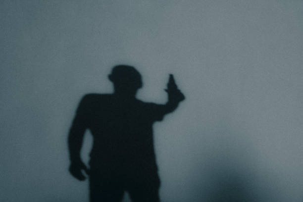 istock Shadow figure. A man drinks alcohol from a bottle. Back view of shadow. Young man with beer bottle 2182267289