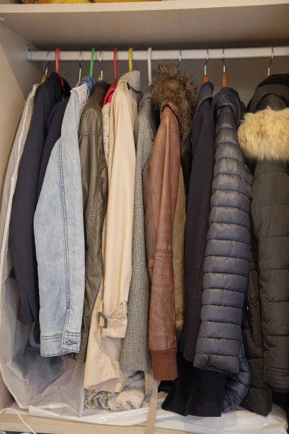 istock A closet filled with various coats and jackets in different colors and materials, including denim, leather, and puffer styles, hung on a row of colorful hangers. 2182275626