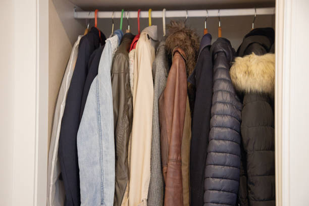 istock A closet filled with various coats and jackets in different colors and materials, including denim, leather, and puffer styles, hung on a row of colorful hangers. 2182275641