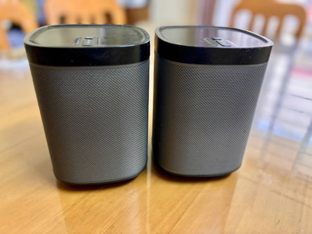 Two black speakers sit on a wooden table