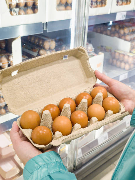 istock Hand with packages of eggs in store 2182286108