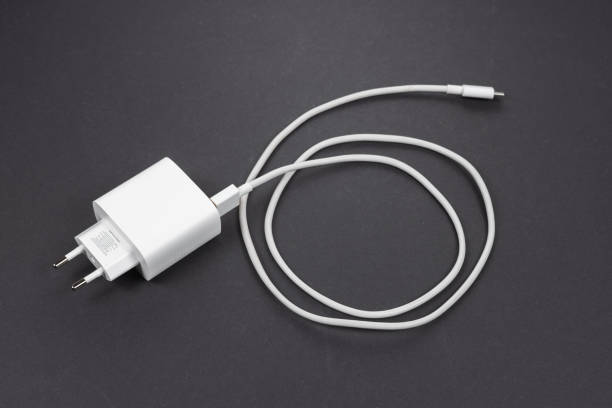 istock White smartphone charger and USB cable on dark background 2182290550