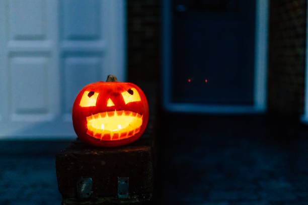istock Illuminated Jack O' Lantern outside residential house on Halloween 2182298076