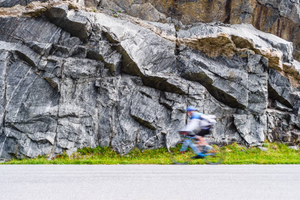 Biker cyclist driving riding in high speed, sport person blurry taking part of sports competition in Norway mountains.