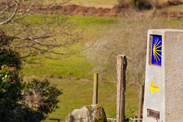 'camino de Santiago', milestone directional sign with scallop symbol and yellow arrow. Lugo province, Galicia, Spain