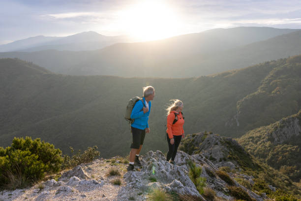 istock Mature couple hike along sunny mountain ridge 2182305385