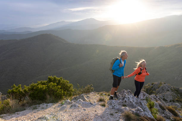 istock Mature couple hike along sunny mountain ridge 2182305404