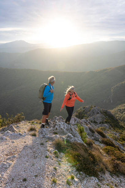 istock Mature couple hike along sunny mountain ridge 2182305452