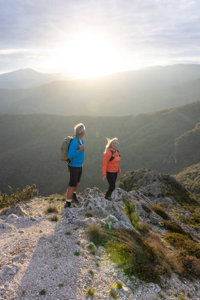 istock Mature couple hike along sunny mountain ridge 2182305499