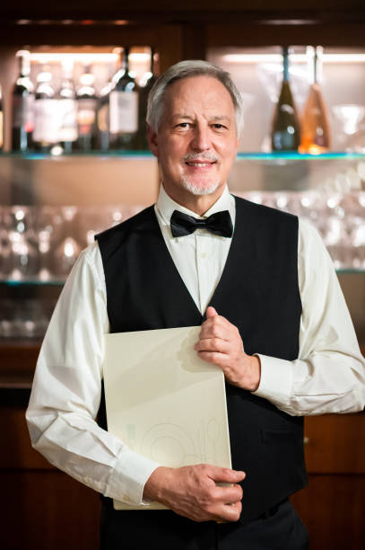 istock Senior waiter holding a menu and smiling in a restaurant 2182306080