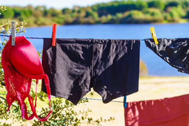 Woman hangs her laundry on the balcony on a sunny day