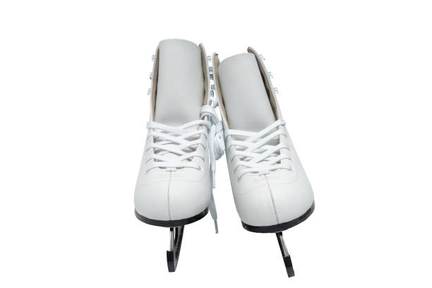close-up view of white figure skating skates, worn on legs, young girl stands on ice surface, active holidays in winter