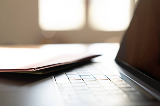 istock Manila folder resting on laptop keyboard in bright home office 2182312670