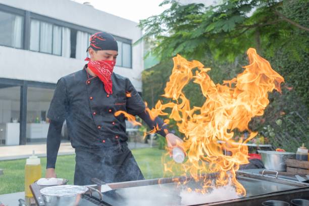 Chef preparing Japanese food on the grill doing a preformance with fire