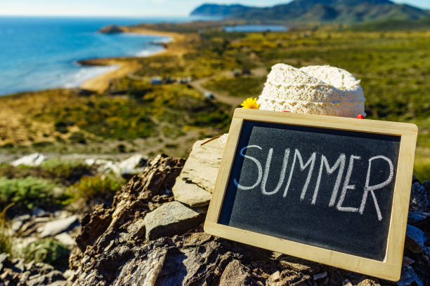 Black board with word summer against spanish sea coast. Landscape of Calblanque Park in Murcia Spain. Travel and holidays.