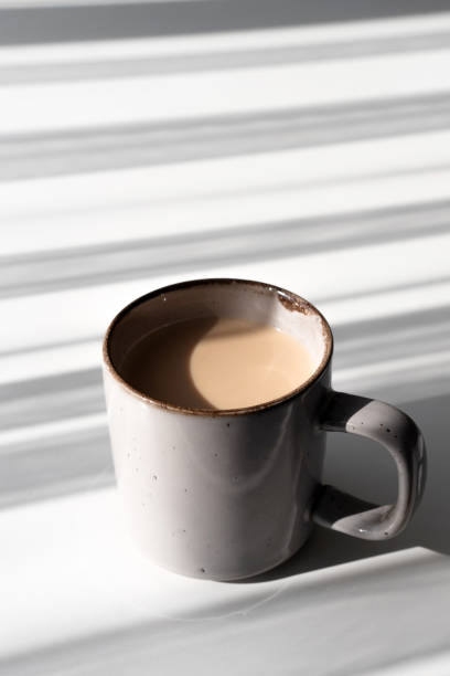 istock Ceramic Mug of Coffee or Tea Casting a Strong Shadow on a White Surface 2182316314