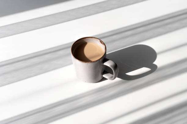 istock Top View of Ceramic Mug of Coffee or Tea Casting a Strong Shadow on White Surface 2182316315