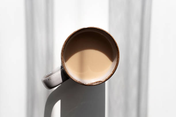 istock Top View of Ceramic Mug of Coffee or Tea Casting a Strong Shadow on White Surface 2182316334