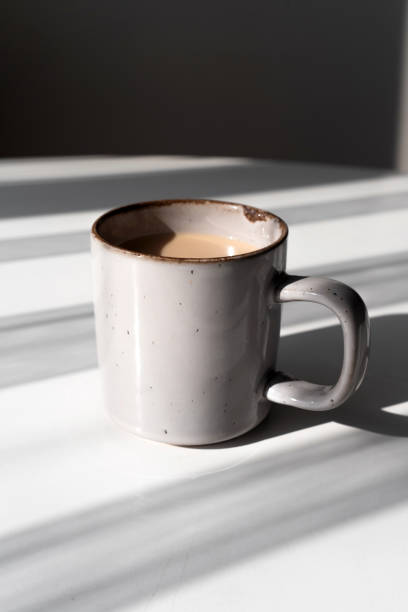 istock Ceramic Mug of Coffee or Tea Casting a Strong Shadow on a White Surface 2182316354