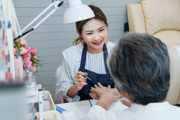 istock Nail technician engages with elderly Asian client, creating an enjoyable and relaxing manicure experience in a welcoming nail salon. Technicians friendly demeanor enhances clients comfort 2182317786
