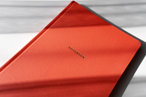 istock Minimalist Red Notebook with Shadows on White Background for Study or Office Themes 2182319859