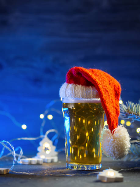 istock beer glass in a Santa hat on a blue background. copy space 2182321657