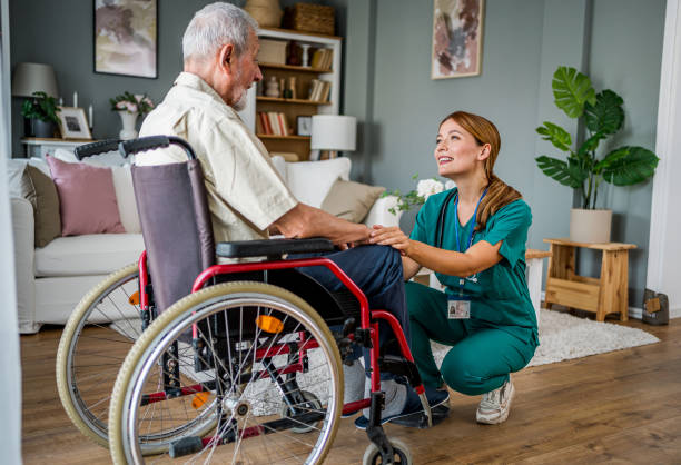 istock Senior man with disability talking with female home nurse 2182321979