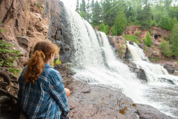 istock Rear View of Girl Looking at Waterfall 2182323090