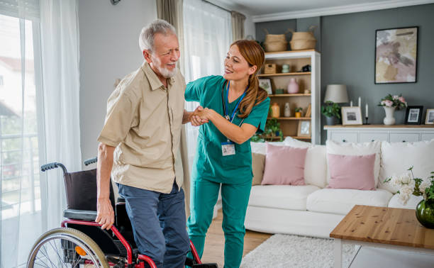 istock Nurse helping a senior man get up from a wheelchair 2182323489