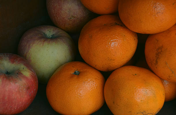 A collection of apples and oranges stacked together in a shelf, emphasizing natural colors and freshness