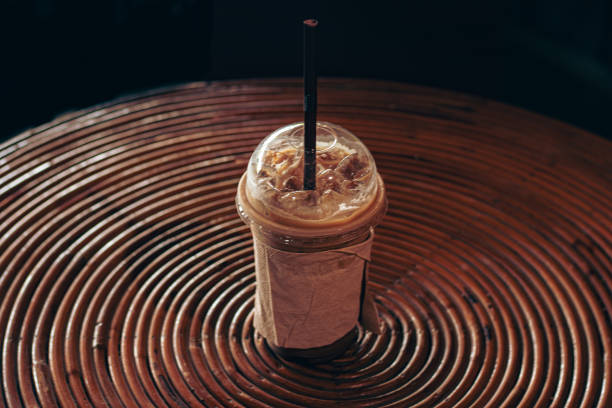 istock Iced coffee in a plastic cup with straw on a spiral patterned rattan table 2182323651
